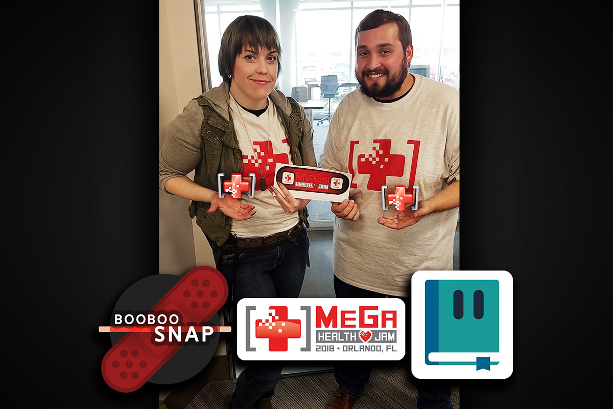 Female and Male student holding marketing swag from their game Boo Boo Snap