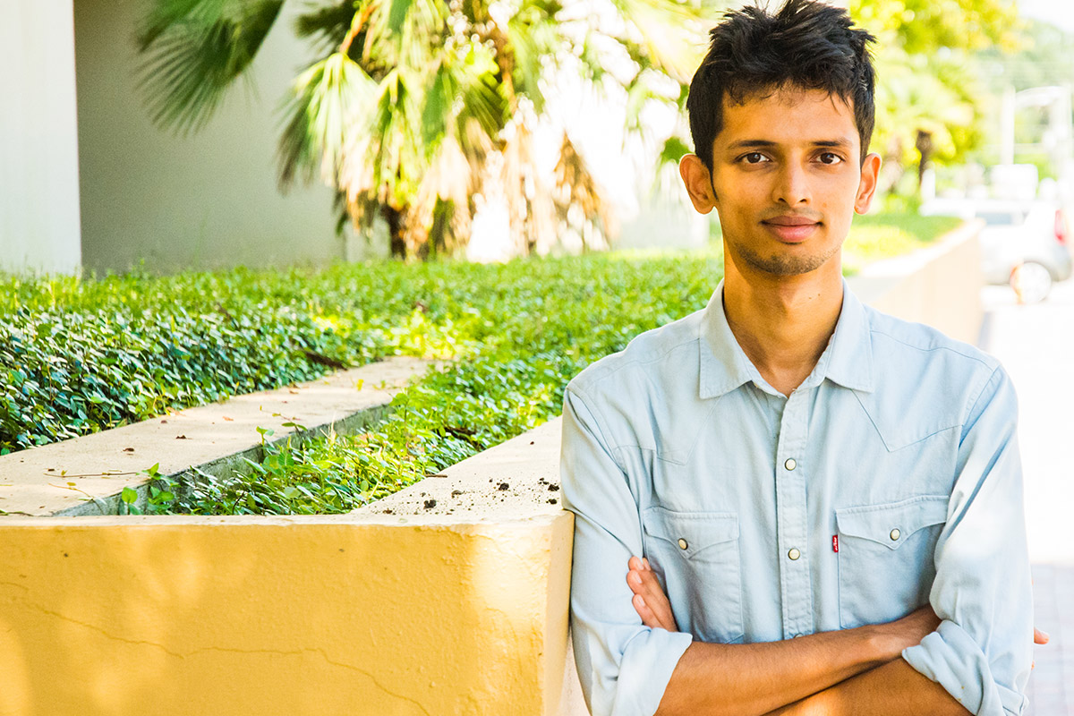 Male indian student standing outside of FIEA building