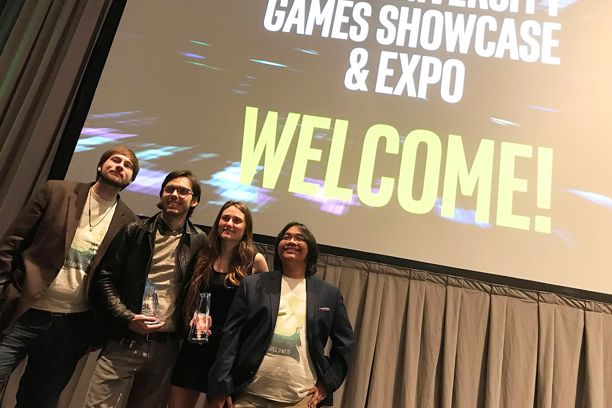 Group of students standing infront of game showcase screen