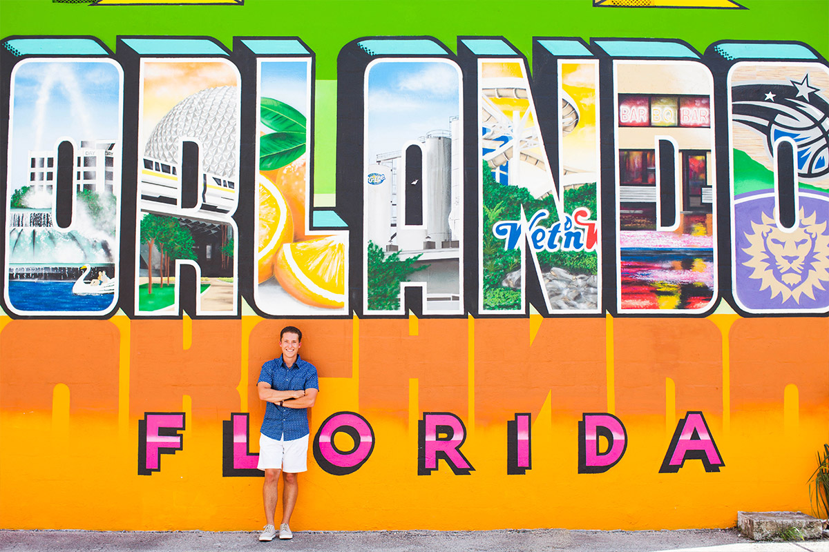 Male student leaning on wall with Orlando Florida graphic design graffiti