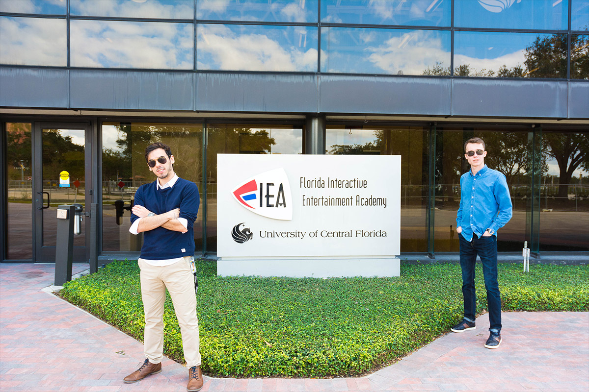 Two male students standing outside infront of FIEA sign