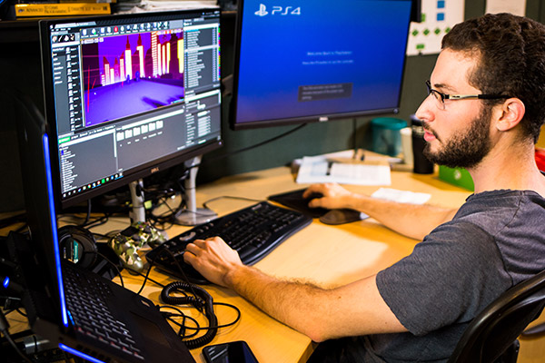 Male student working at his desk in game engine software