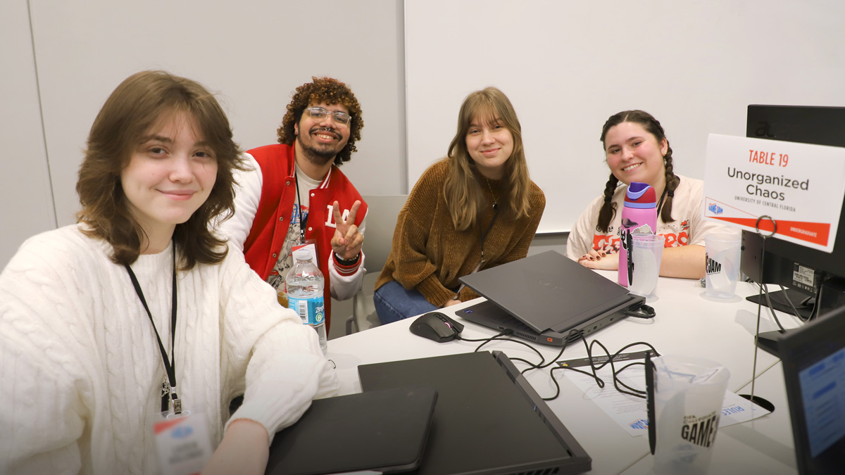 Group of participants sit in a group on one side of a round table with their laptops open. Team name: Unorganized Chaos from UCF, undergraduate division.