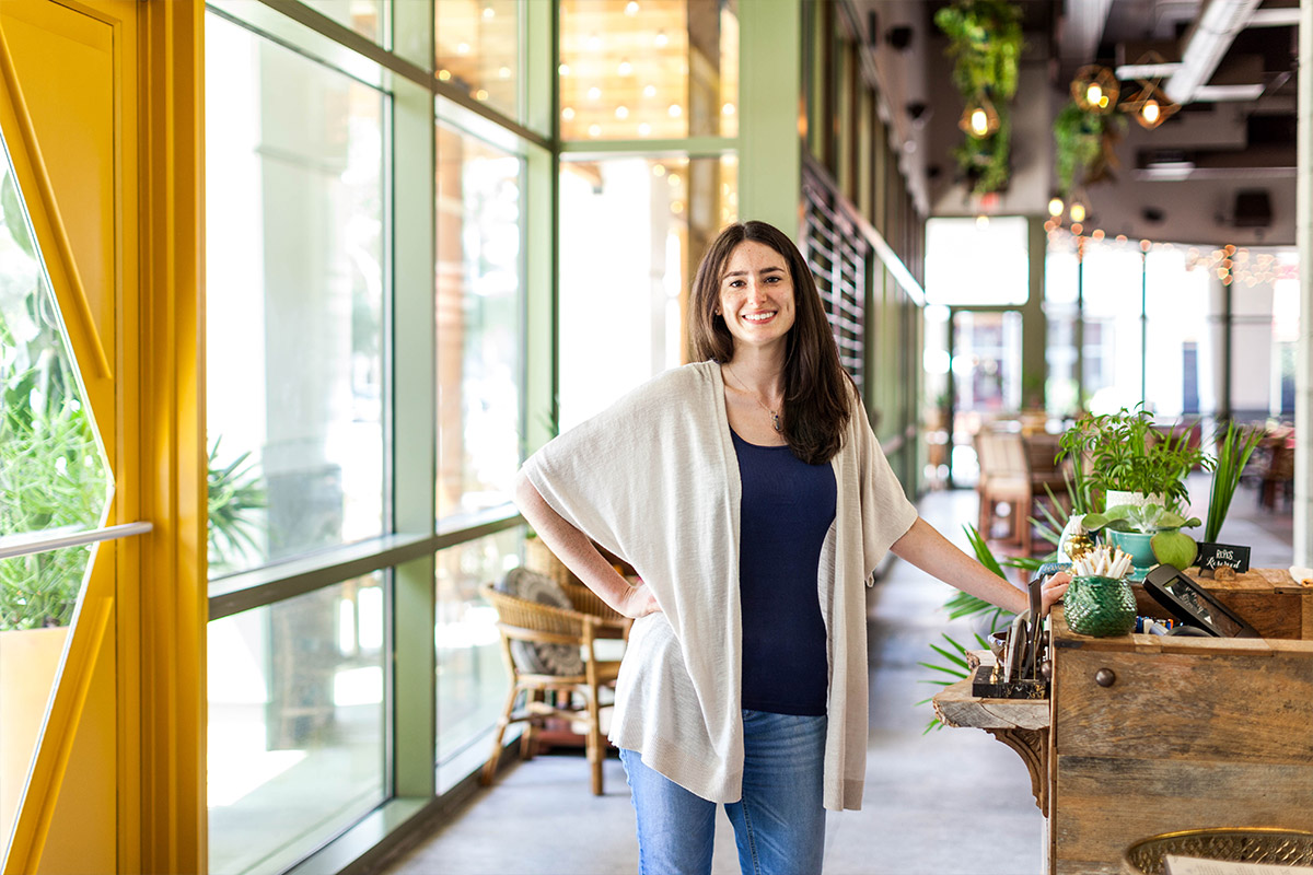 Female student standing inside a rustic looking resturant