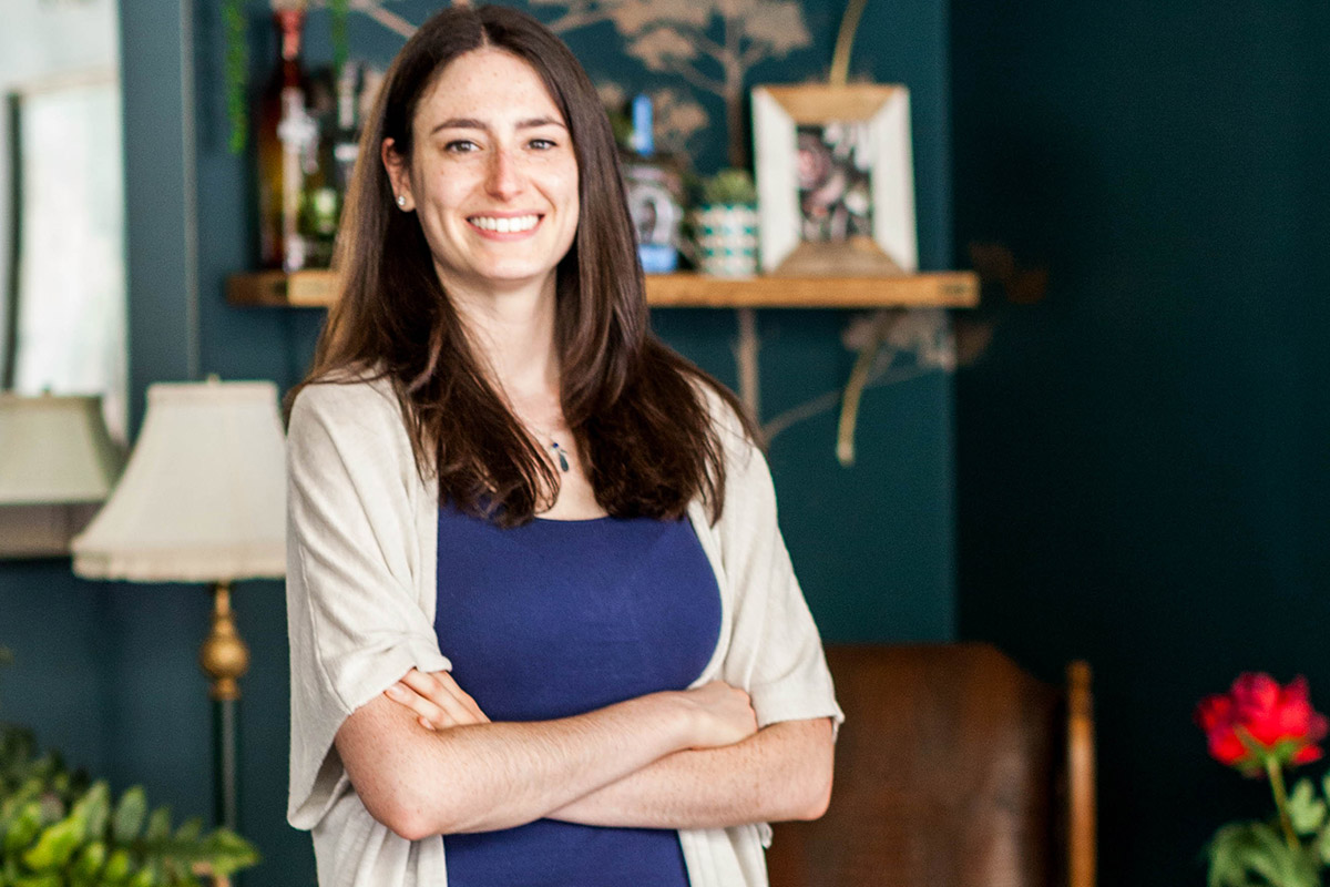 Female student standing inside a rustic looking resturant