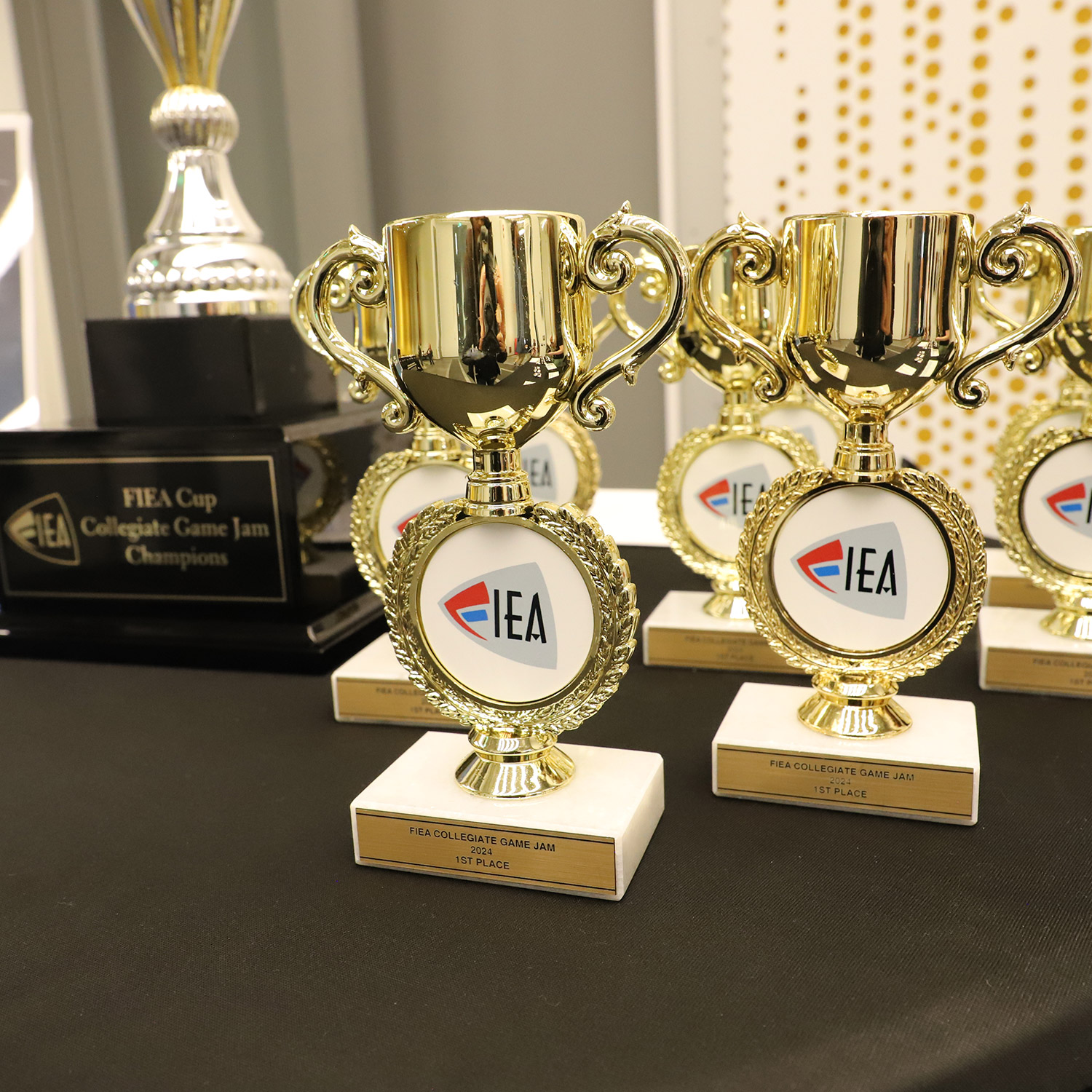 Eight trophies line a table at the registration area before the game jam.