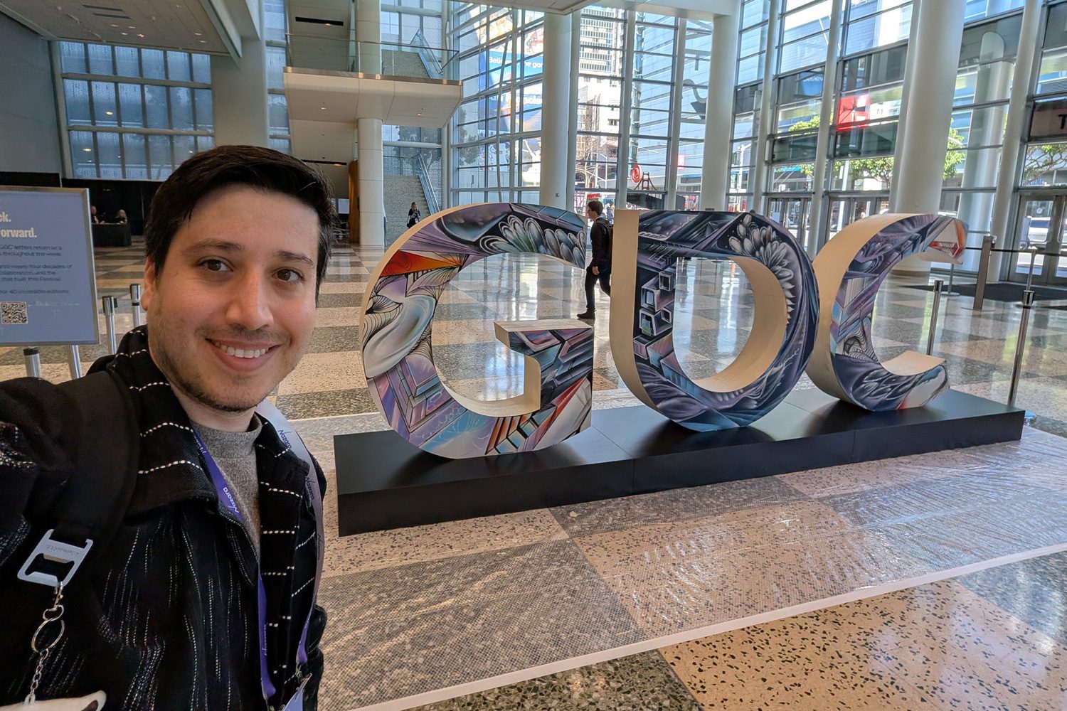 Barak Moshe, Cohort 7, takes a selfie at the freshly painted GDC block letters inside one of the buildings hosting GDC at the Moscone Center in San Francisco in March 2026.