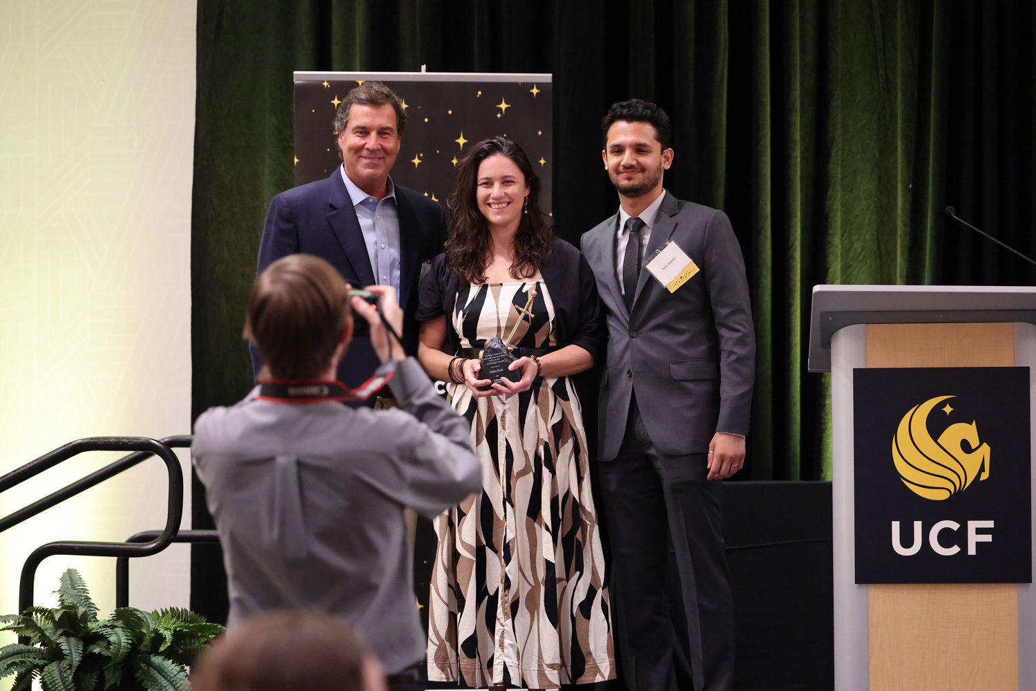 FIEA Executive Director Ben Noel and Tech Art Instructor Nitin Bakshi present Nikki Roth with the NSCM Hall of Fame award.
